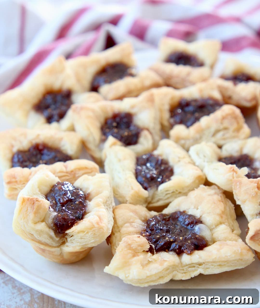 Baked puff pastry bites filled with brie and fig jam on plate