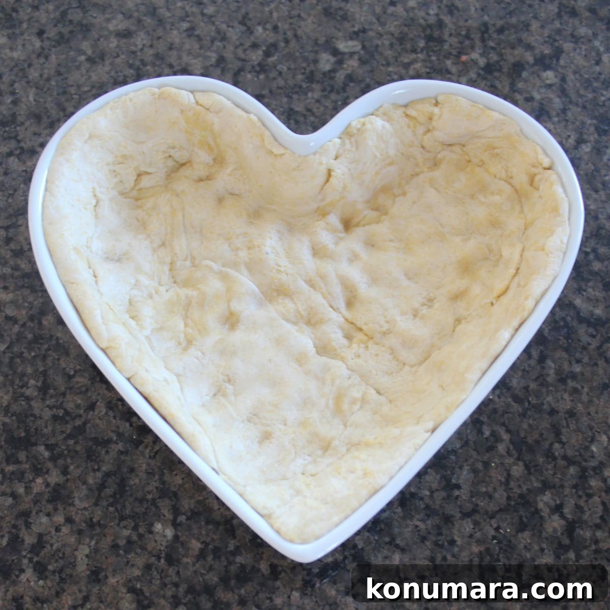 Heart-Shaped Pizza Recipe for Date Night 5 Pizza dough lining the bottom of a heart-shaped pan.