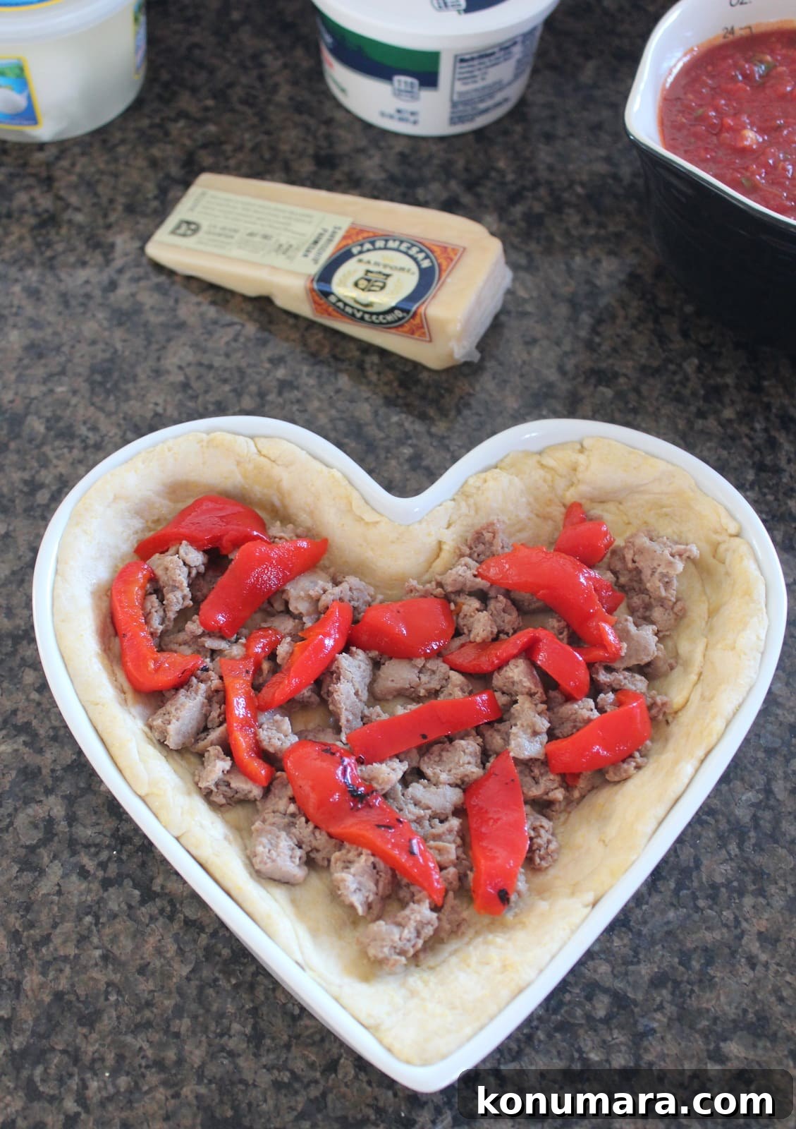 Heart-Shaped Pizza Recipe for Date Night 6 Cooked sausage and roasted red peppers in heart-shaped pizza dough.