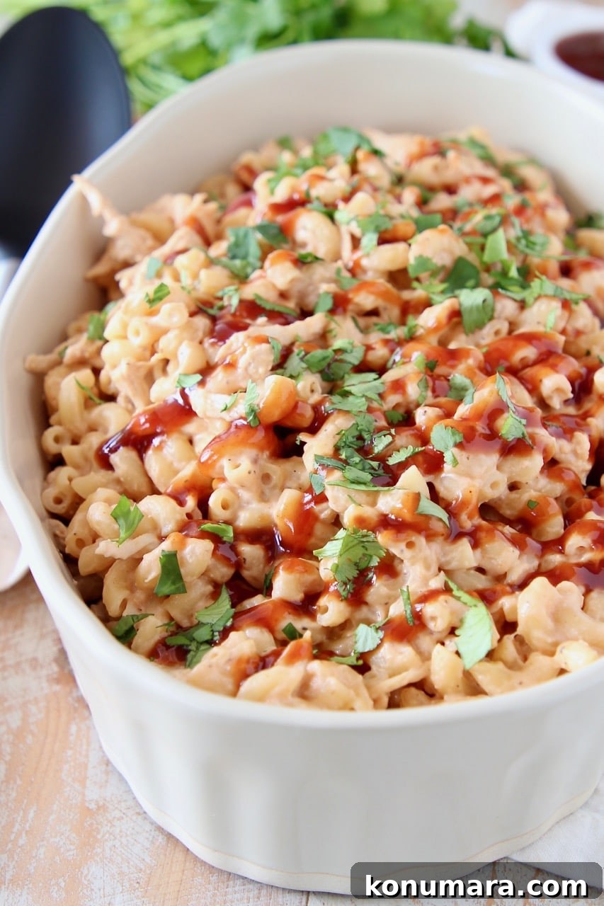 Smoky BBQ Chicken Mac and Cheese Recipe 3 Mac and cheese topped with bbq sauce and cilantro in large oval baking dish