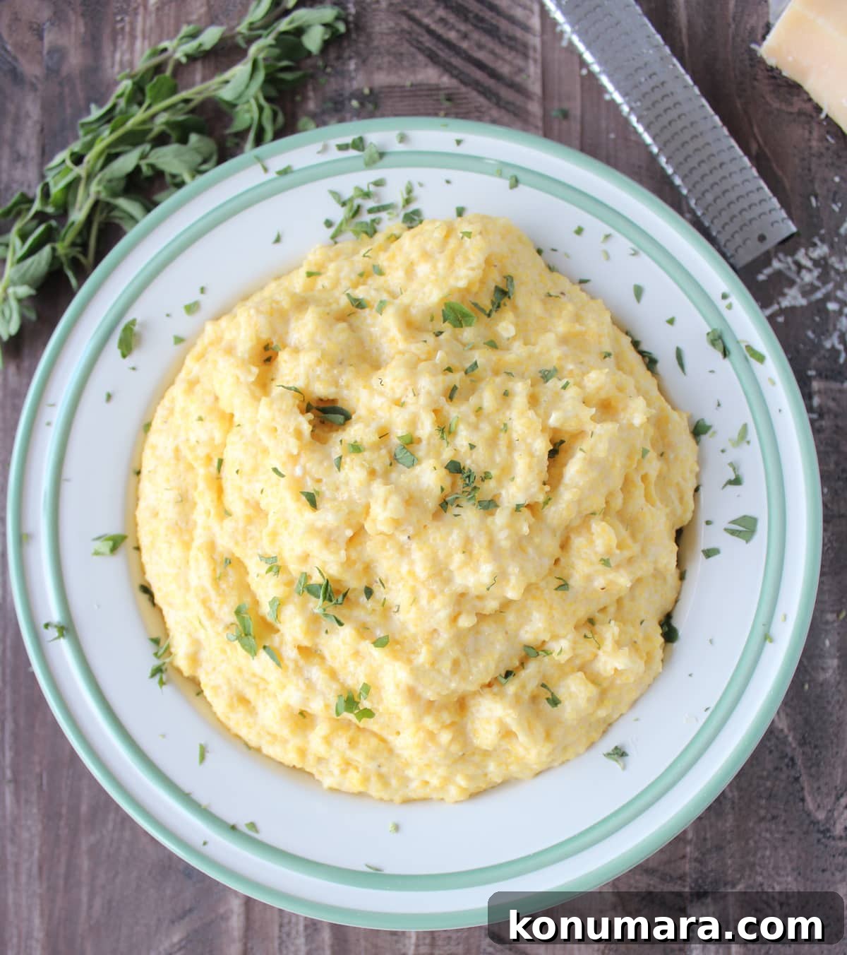 prepared polenta in a bowl topped with fresh chopped herbs