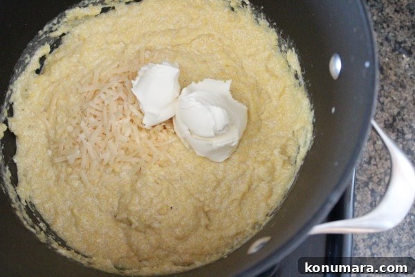 creamy prepared polenta in a large pot topped with different cheeses