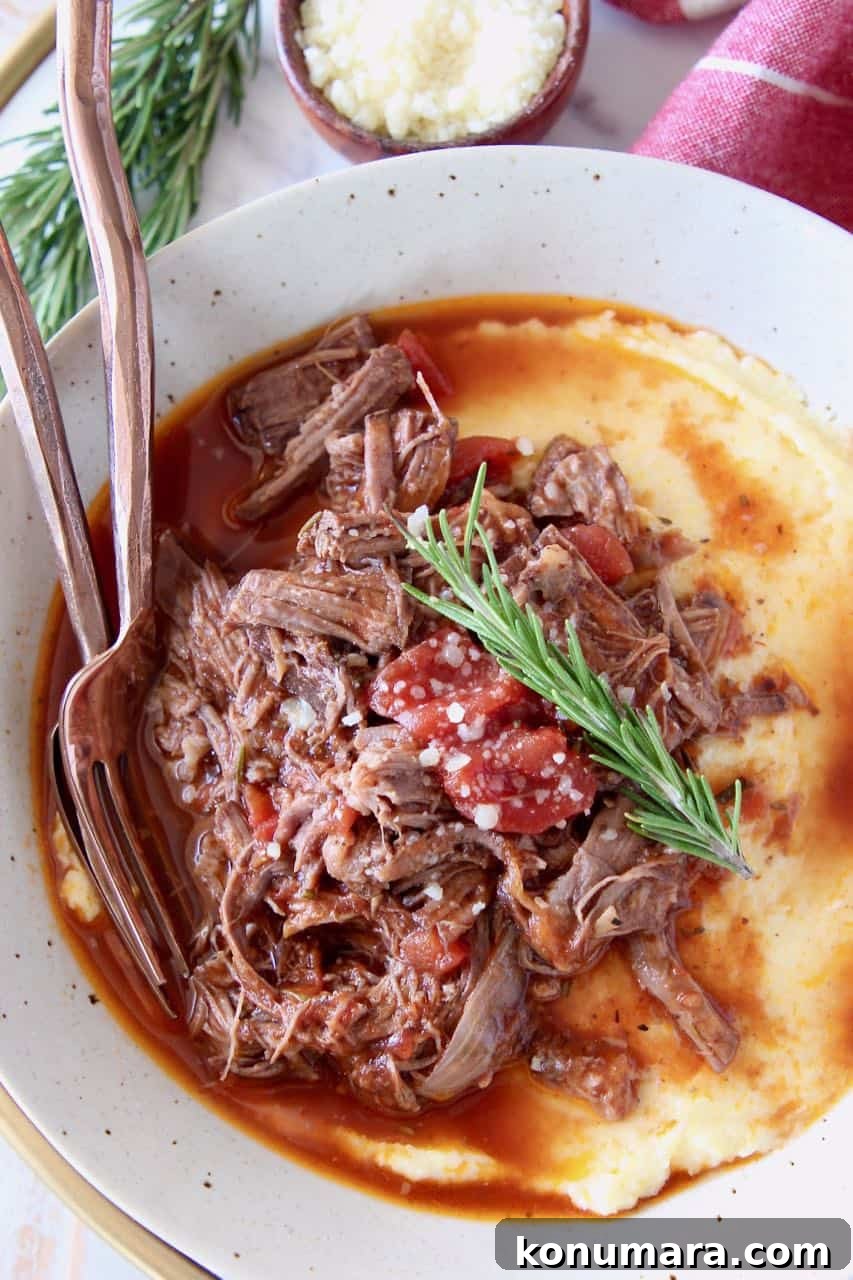 Shredded beef ragu sauce served over creamy polenta in bowl
