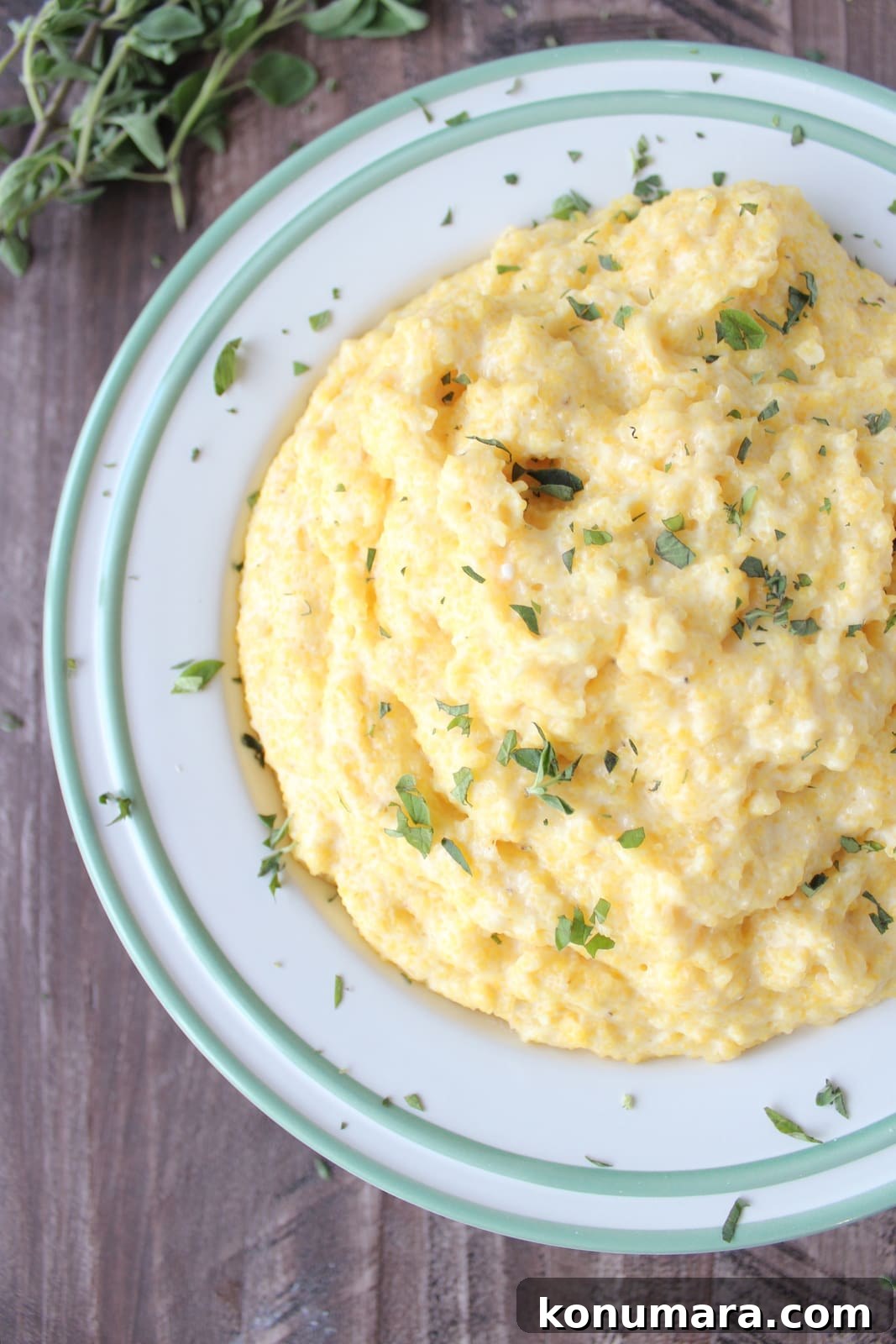 prepared polenta in a bowl topped with fresh chopped herbs