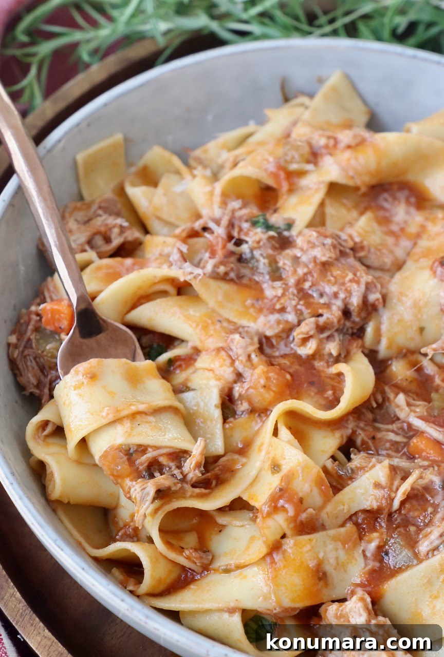 Authentic Slow Simmered Pork Ragu Recipe 12 pasta stirred in fork in bowl with pork ragu sauce