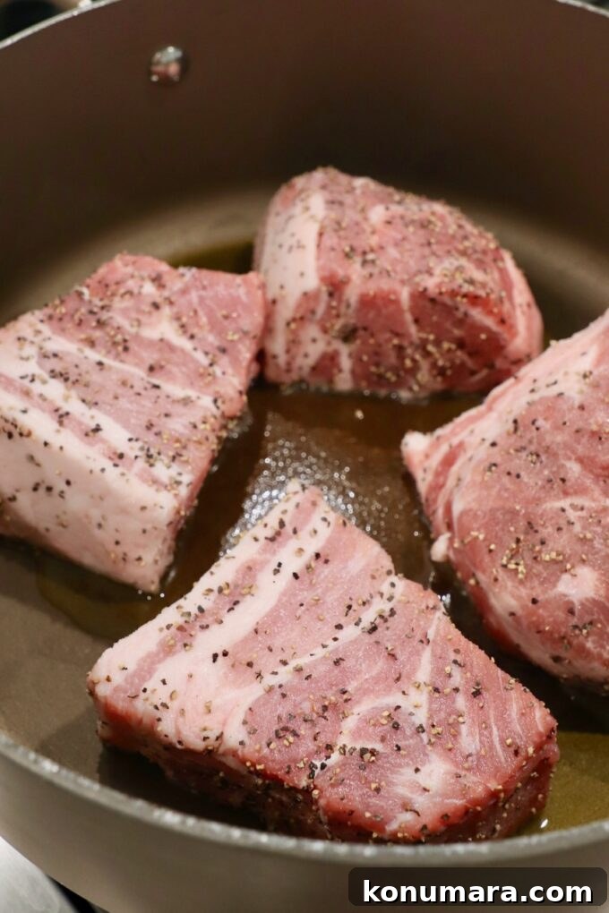 Authentic Slow Simmered Pork Ragu Recipe 4 large pieces of pork shoulder in pot on stove