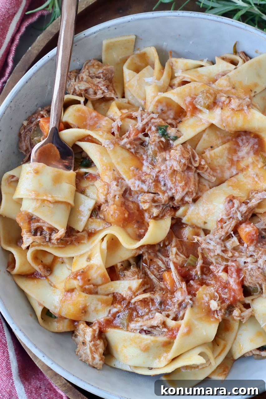 Authentic Slow Simmered Pork Ragu Recipe 10 pappardelle pasta tossed with pork ragu in bowl with fork