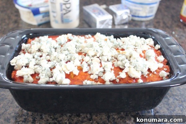 Spicy Buffalo Chicken Meatloaf with Blue Cheese 7 blue cheese crumbles on top of a meatloaf in a loaf pan