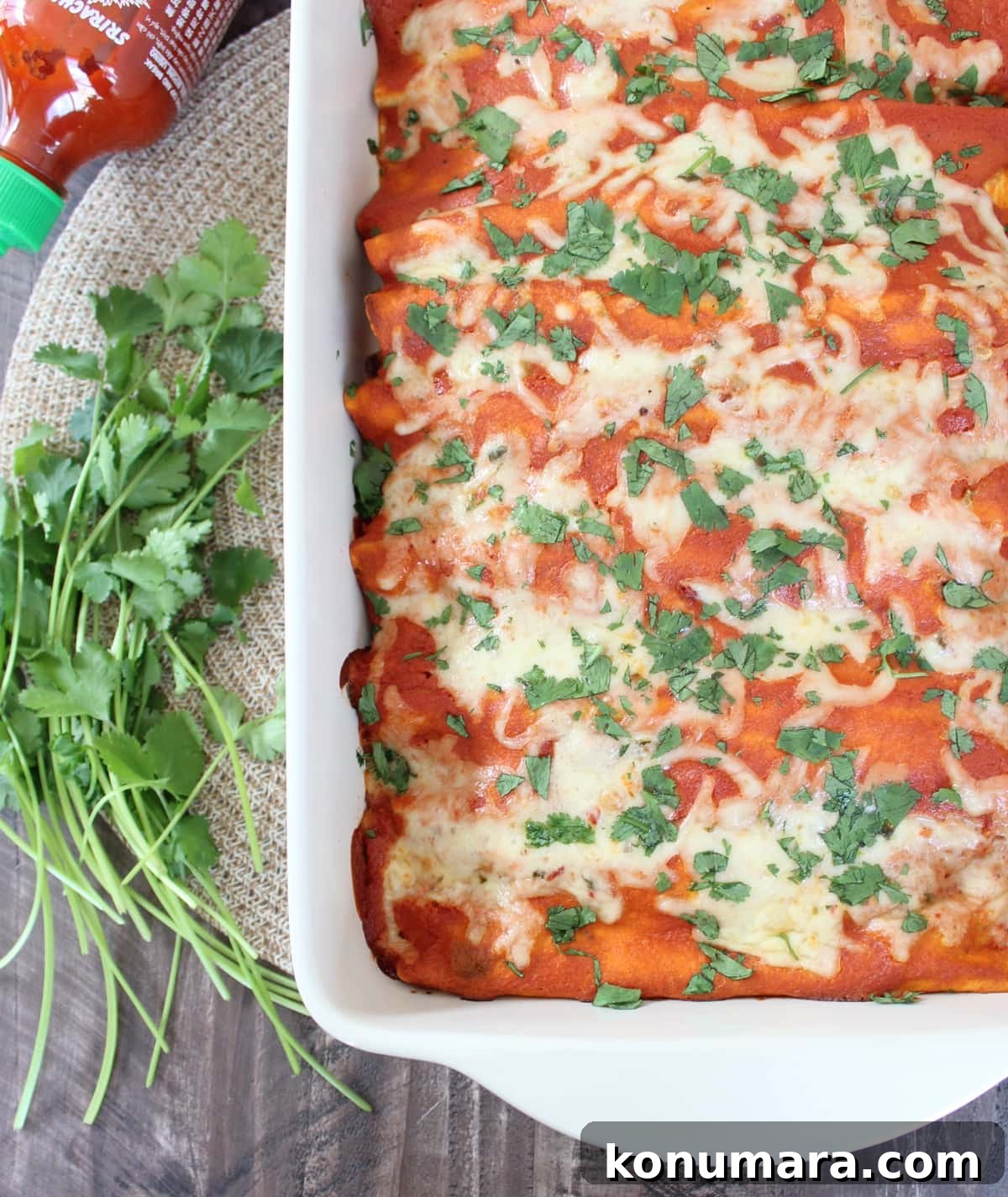 enchiladas in a baking dish topped with fresh chopped cilantro