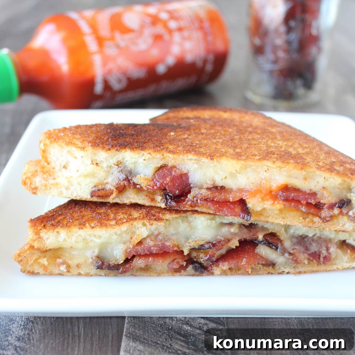 bacon grilled cheese sandwich cut in half stacked up on a plate