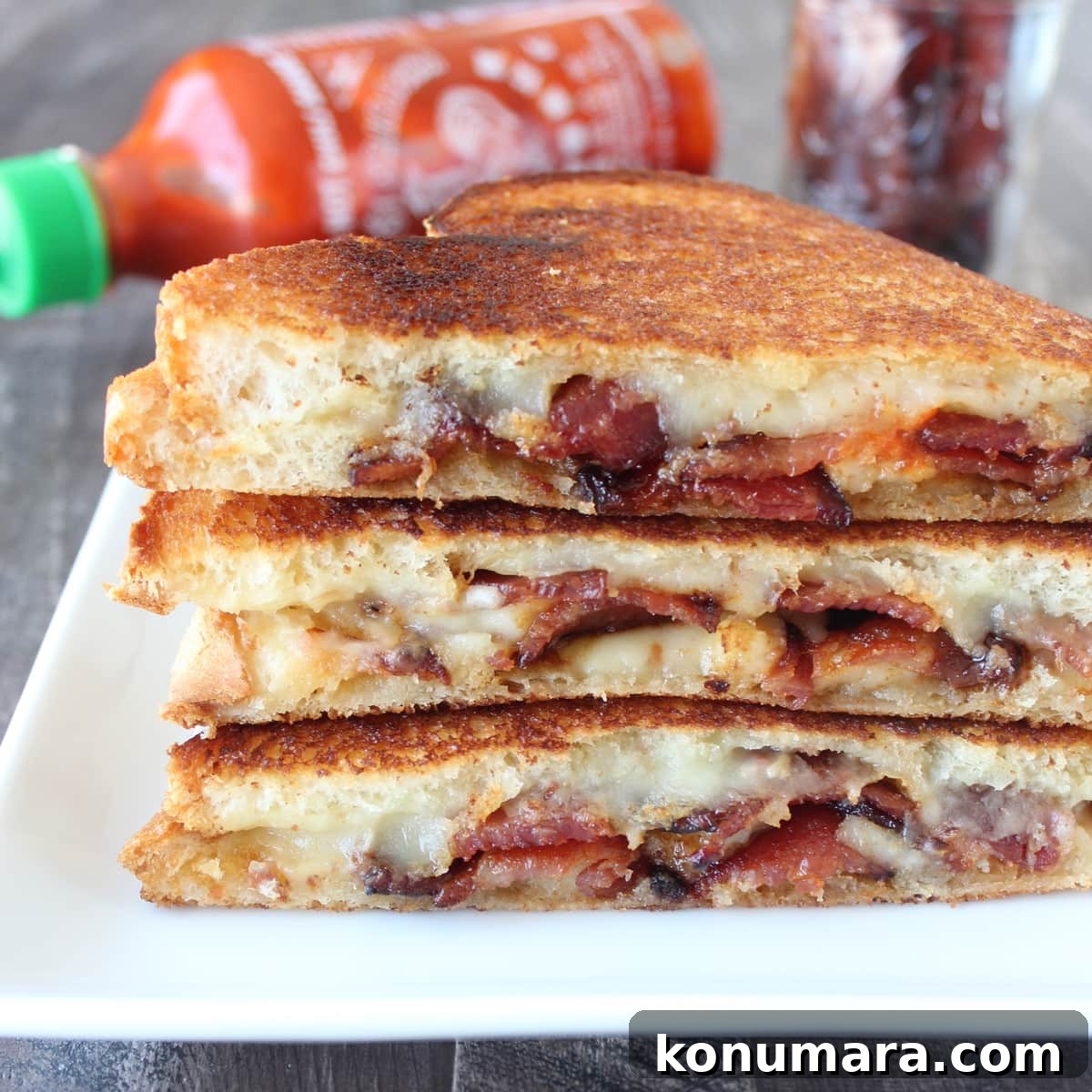 bacon grilled cheese sandwiches cut in half and stacked up on a plate