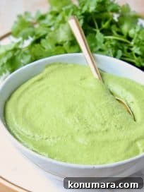 Cilantro pesto in white bowl with gold spoon