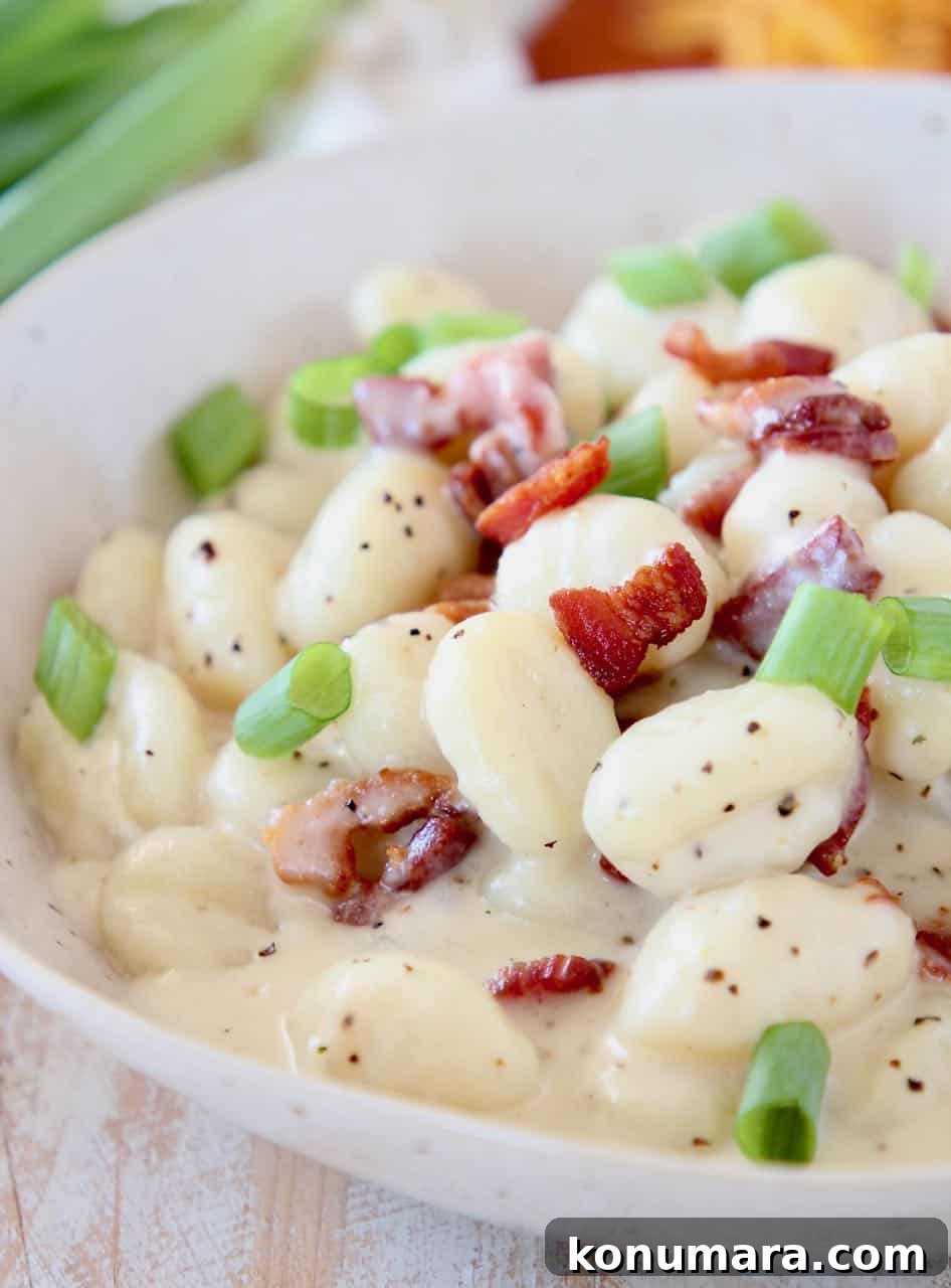 One-Pot Baked Potato Gnocchi Recipe 2 Potato gnocchi in bowl with creamy sauce, bacon pieces and diced green onions