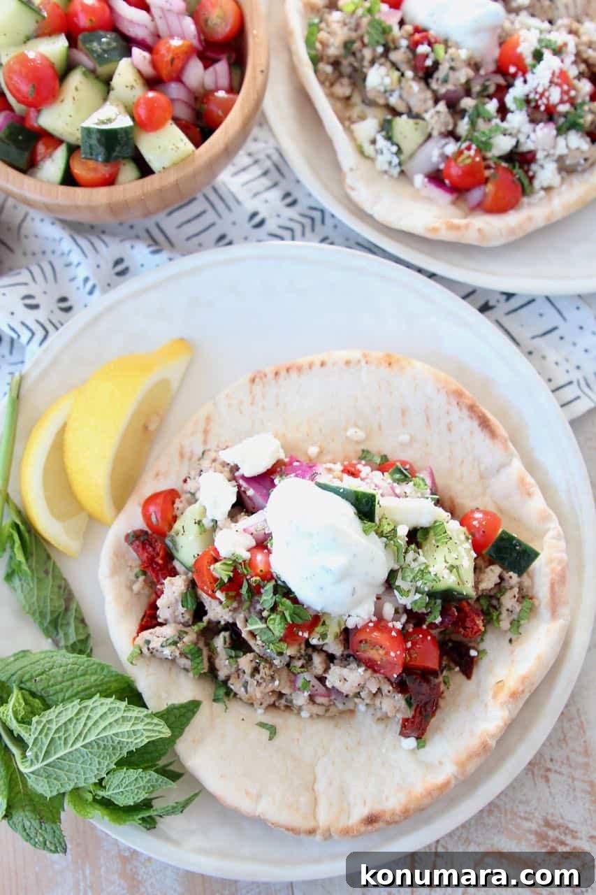 Savory Ground Turkey Gyros with Tzatziki and Pita 3 Ground turkey tacos in pita bread on plate, topped with tzatziki sauce