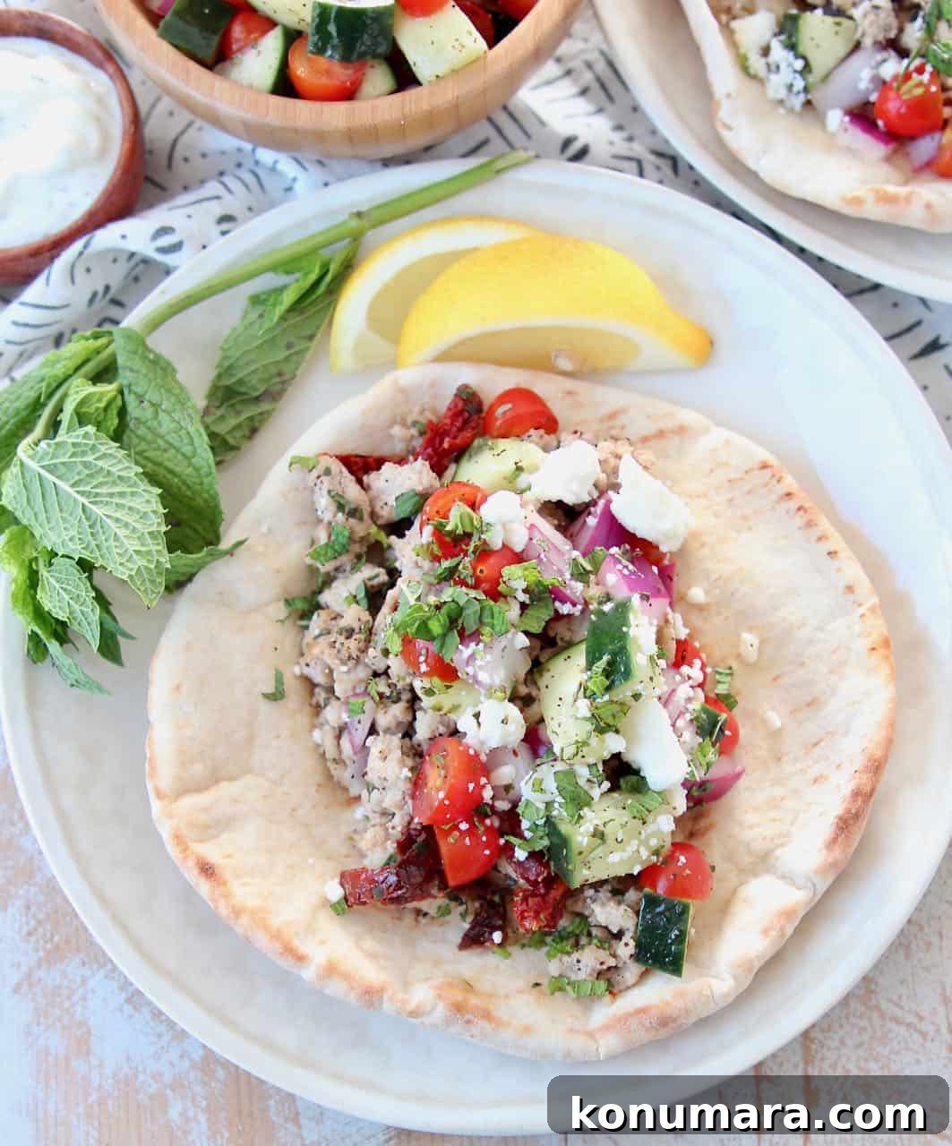 Savory Ground Turkey Gyros with Tzatziki and Pita 4 Ground turkey taco in pita bread with tomato cucumber salsa on white plate