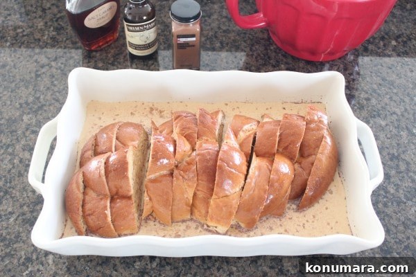Salted Caramel Praline French Toast Recipe 6 Sliced bread soaking in a milk and egg mixture in a casserole dish.