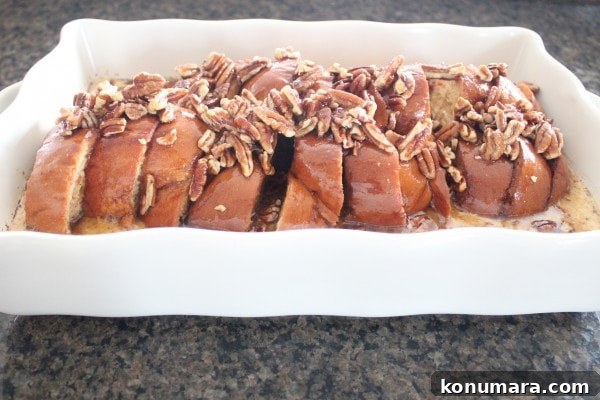 Salted Caramel Praline French Toast Recipe 8 Sliced bread in a casserole dish topped with pecans.