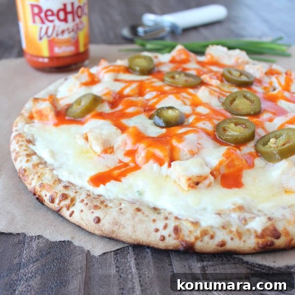 Buffalo Chicken Dip Pizza Recipe 2 Pizza topped with melted cheese, chicken, buffalo sauce, and jalapeño slices.