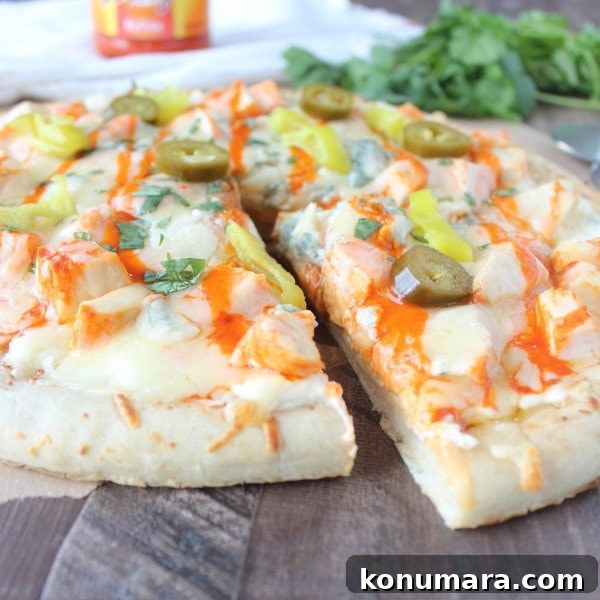 Buffalo Chicken Dip Pizza Recipe 11 A slice of Buffalo Chicken Dip Pizza being removed from the pizza.