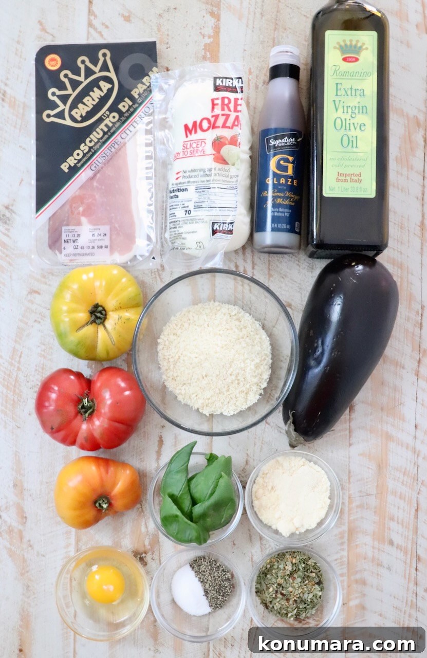 Assorted ingredients for an Italian dish on a wooden surface: eggplant, colorful heirloom tomatoes, prosciutto, mozzarella, panko breadcrumbs, olive oil, basil, egg, and seasonings.