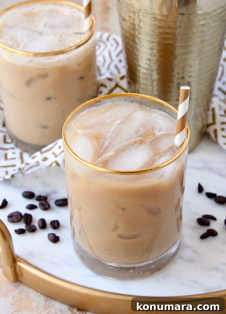 Long island iced coffee cocktail in glass on marble and gold serving tray
