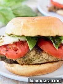 Grilled Chicken Caprese Sandwich with Fresh Mozzarella and Basil 6 Caprese grilled chicken sandwich on white plate with fresh basil in background