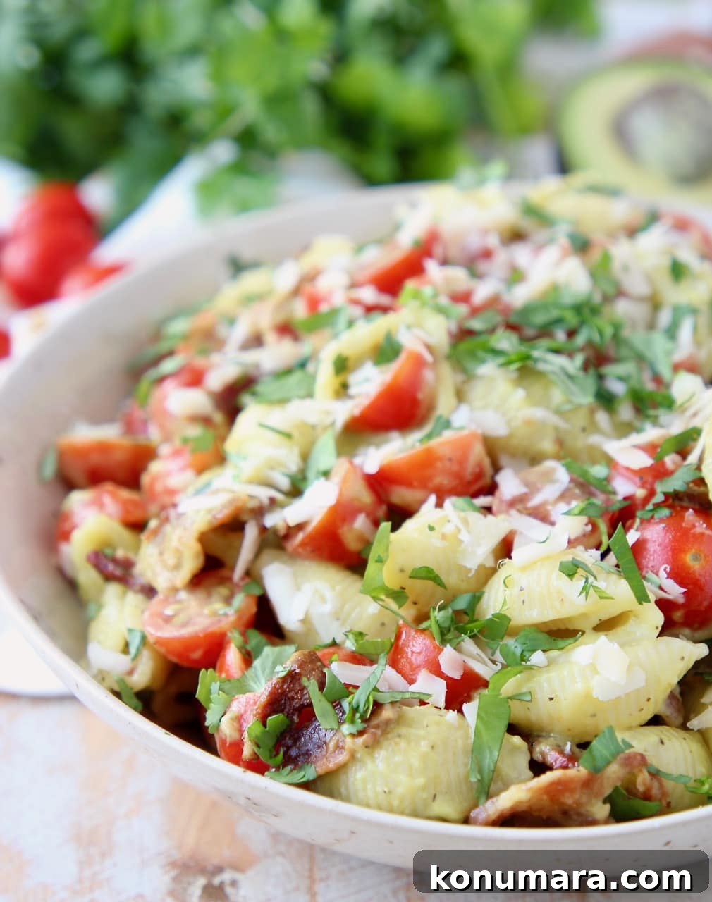 Pasta salad in bowl with bacon, tomatoes and parmesan cheese
