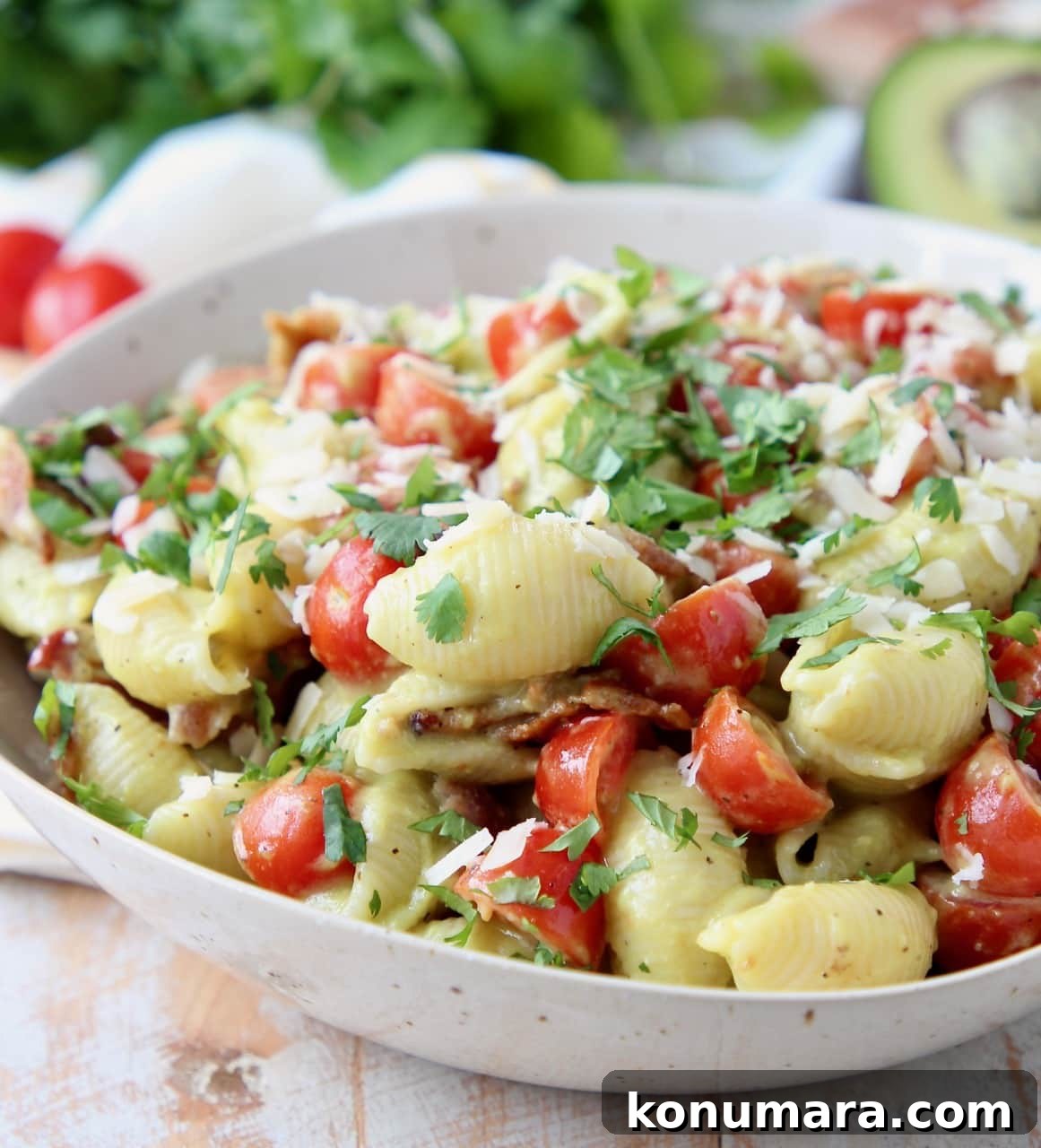 Pasta salad in bowl with diced tomatoes and bacon