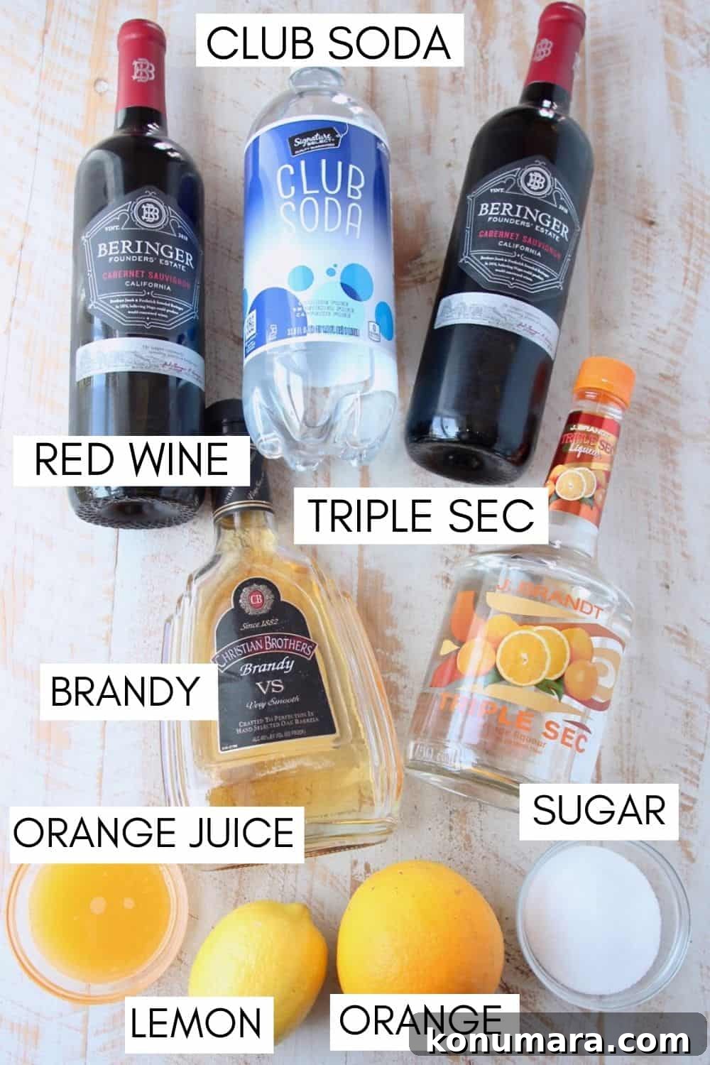 How to Make Classic Red Sangria with Citrus and Berries 5 Ingredients for red sangria on a white wood board