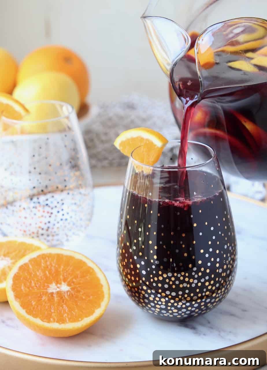 How to Make Classic Red Sangria with Citrus and Berries 7 Sangria poured into glass from pitcher