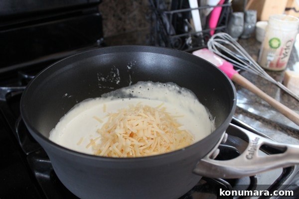 creamy sauce in a skillet with shredded cheese