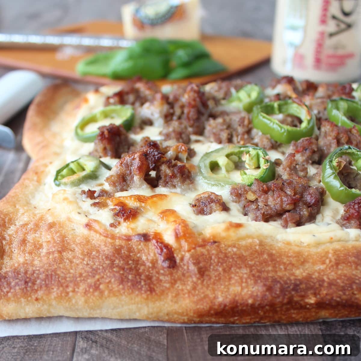 cooked pizza topped with crumbled sausage and sliced jalapenos