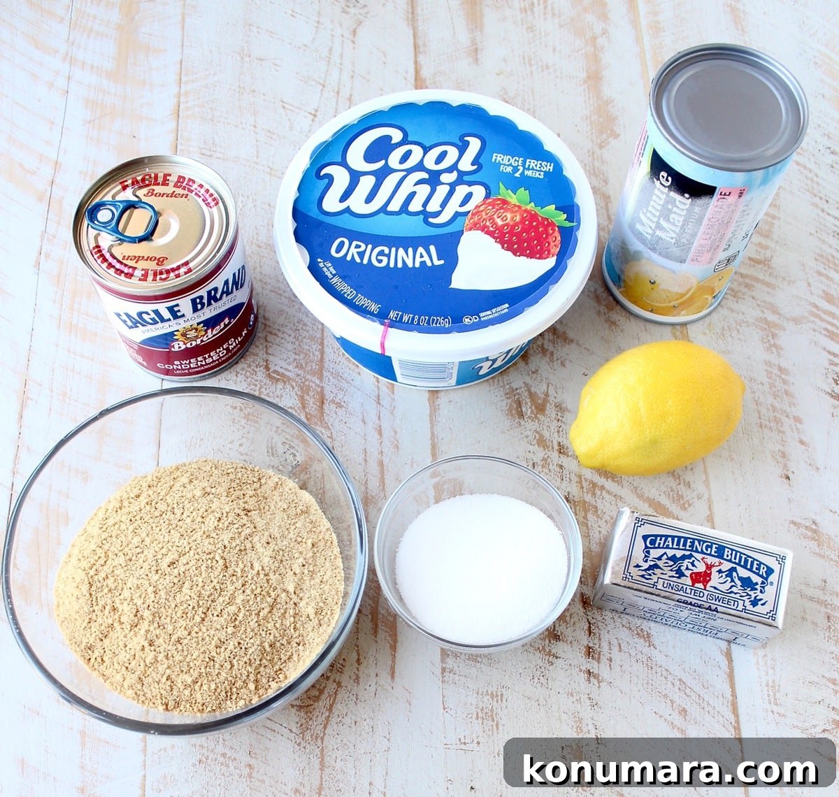 ingredients for frozen lemonade pie on a white wood board