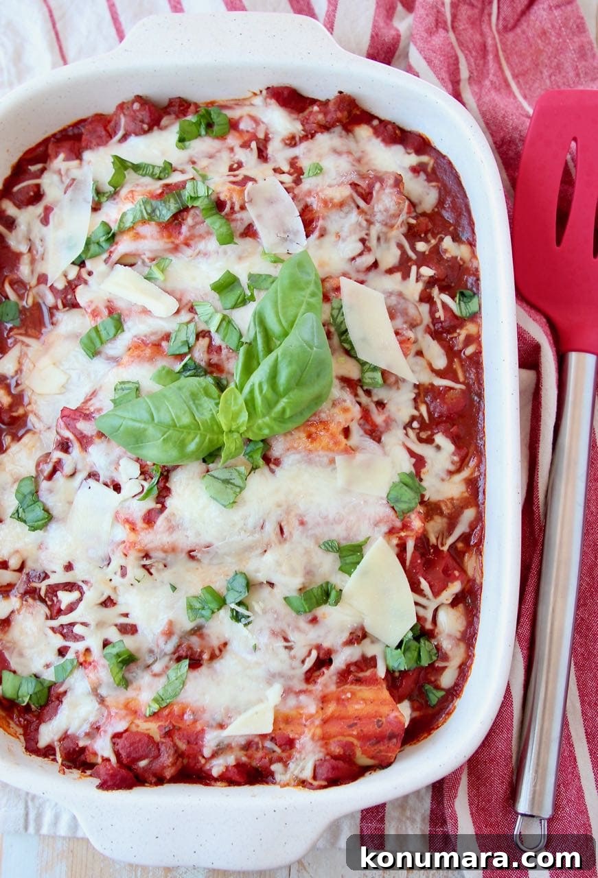 Three-Cheese Manicotti with Italian Sausage Marinara 2 Baked manicotti in casserole dish topped with fresh basil leaves