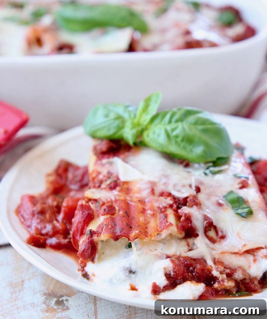 Three-Cheese Manicotti with Italian Sausage Marinara 3 Cheese manicotti on plate, topped with marinara sauce and fresh basil leaves
