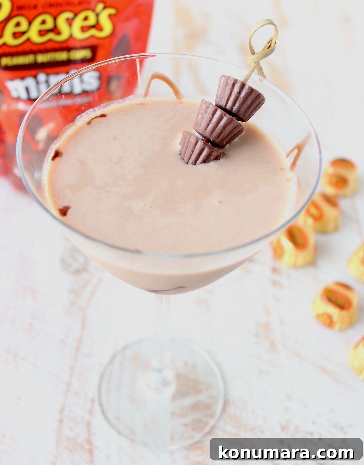 Reese's Martini in martini glass with skewer of mini Reese's peanut butter cups and orange bag of Reese's peanut butter cups