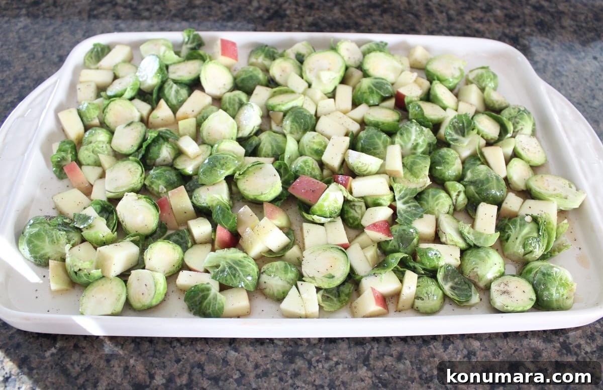 Crispy Maple-Glazed Roasted Brussels Sprouts 5 brussels sprouts and diced apples in an even layer on a baking sheet
