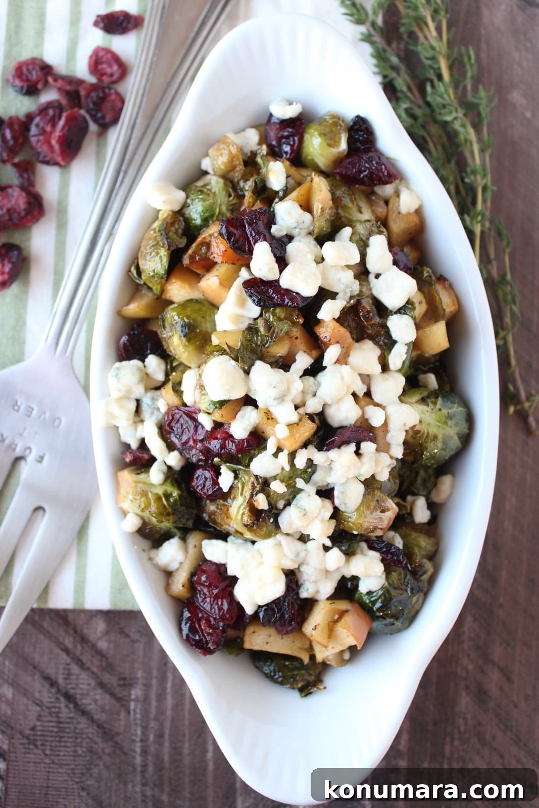 Crispy Maple-Glazed Roasted Brussels Sprouts 7 Roasted Brussel Sprouts in serving bowl topped with dried cranberries and gorgonzola cheese crumbles