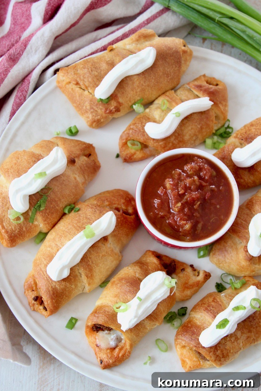baked taco croissants on plate topped with sour cream