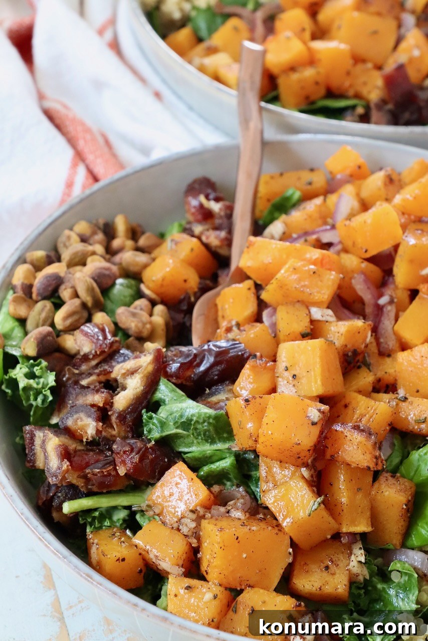 Roasted Butternut Squash Salad with Maple Vinaigrette 2 roasted diced butternut squash on top of a salad in a bowl