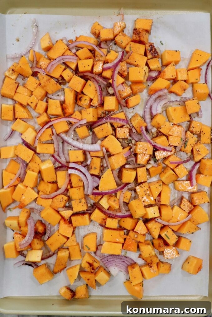 Roasted Butternut Squash Salad with Maple Vinaigrette 4 cubed butternut squash with sliced onions and minced garlic on a parchment paper lined baking sheet