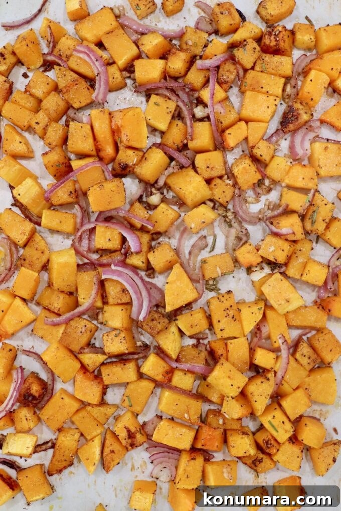 Roasted Butternut Squash Salad with Maple Vinaigrette 5 roasted cubed butternut squash with sliced onions and minced garlic on a parchment paper lined baking sheet