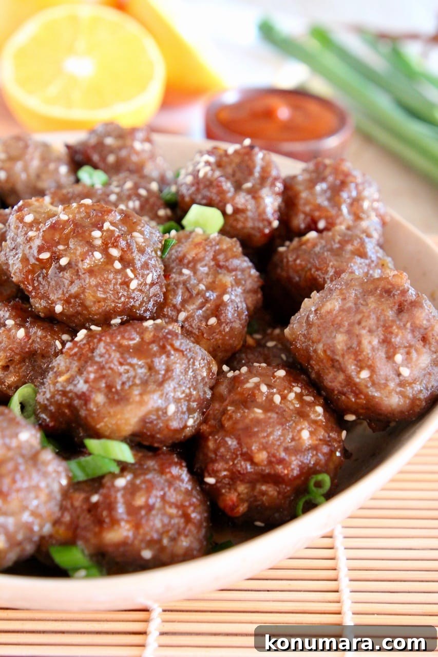 Chinese meatballs in bowl with diced green onions and sesame seeds