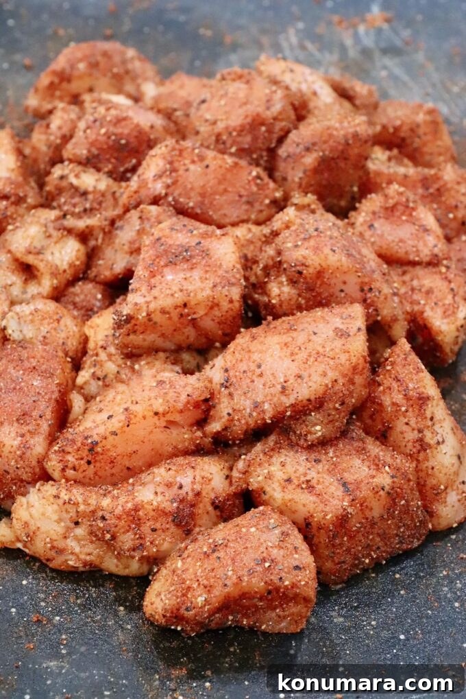 seasoned raw cubes of chicken on a cutting board