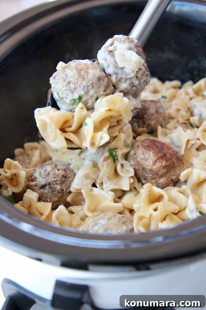 Slow Cooker Swedish Meatballs Recipe with Creamy Gravy 3 Swedish meatballs being spooned out of slow cooker