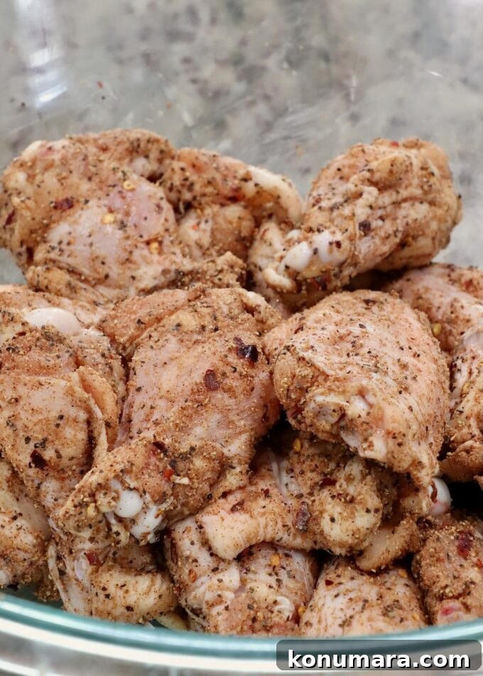 seasoned raw chicken wings in a glass bowl