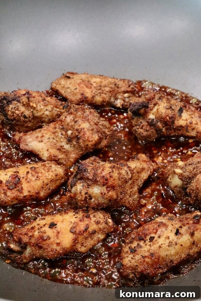 cooked chicken wings in a wok with sauce