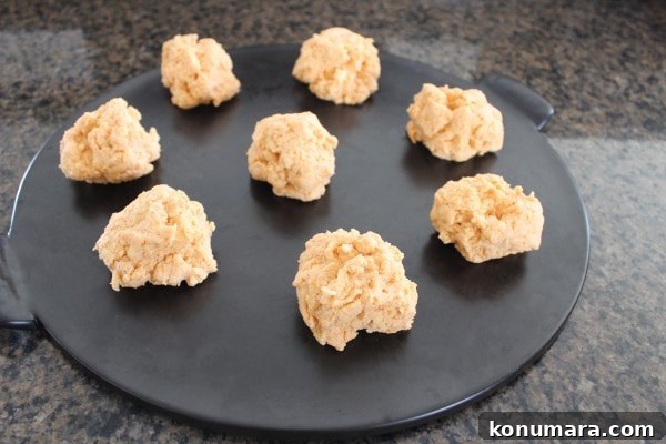 Buffalo Cheddar Biscuits Recipe 5 biscuit dough dolloped on a black round baking stone