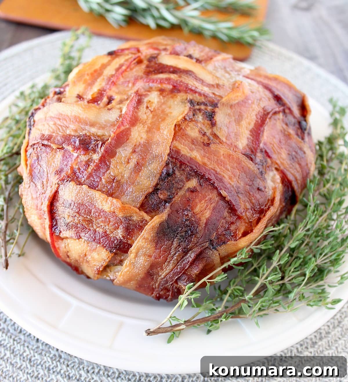 Juicy Bacon-Wrapped Meatloaf Recipe 5 Bacon Wrapped Meatloaf on plate with fresh thyme sprigs