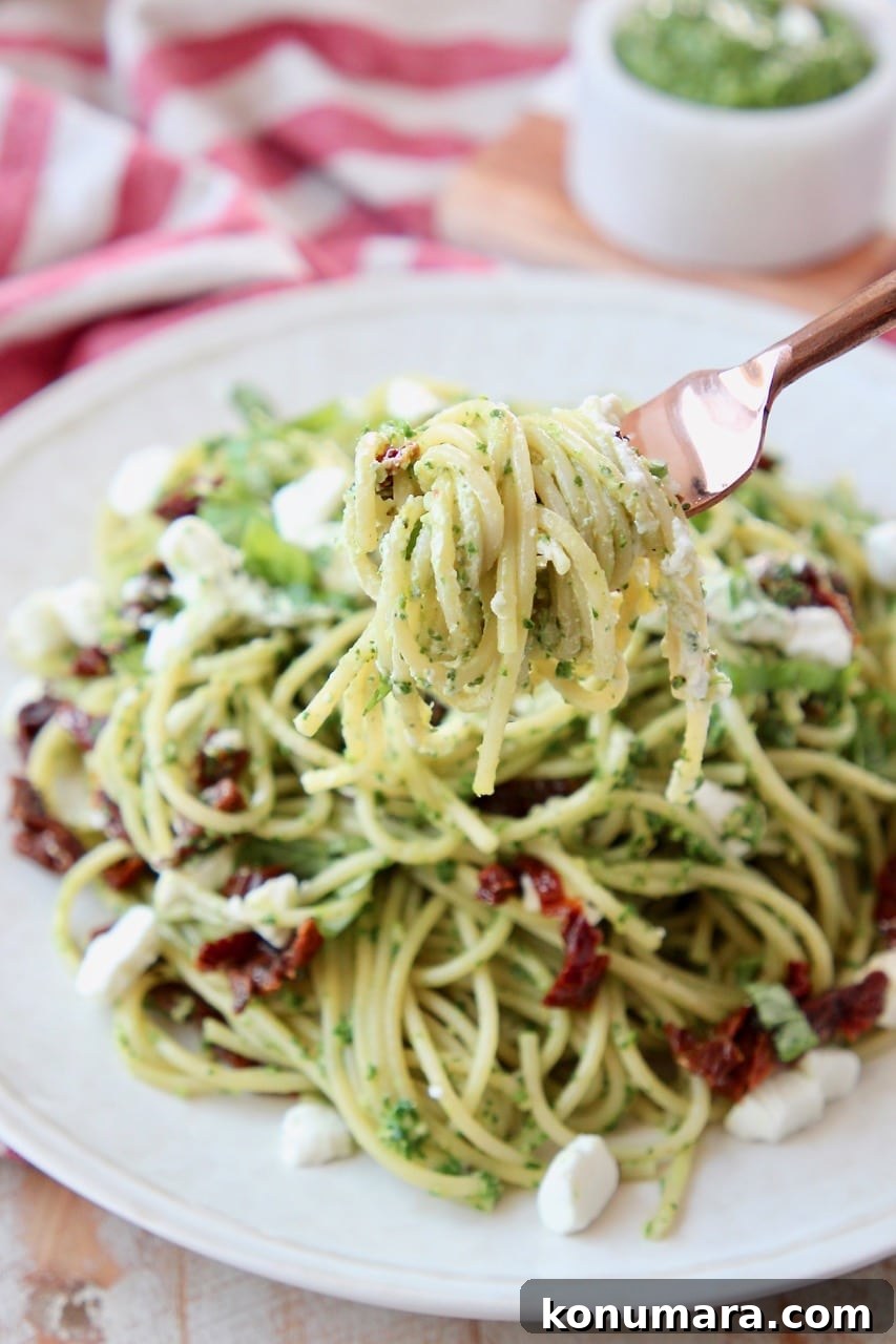 Kale Pesto Spaghetti with Creamy Goat Cheese 4 Pesto spaghetti on plate, with fork twirling the spaghetti lifted over the plate
